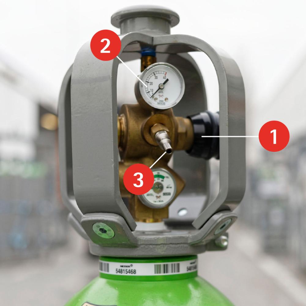 Photo de la tête d'une bouteille Megatop, annotée avec le chiffre 1 qui indique le robinet, le chiffre 2 qui indique le manomètre intégré et le chiffre 3 qui indique le raccord rapide de la bouteille.